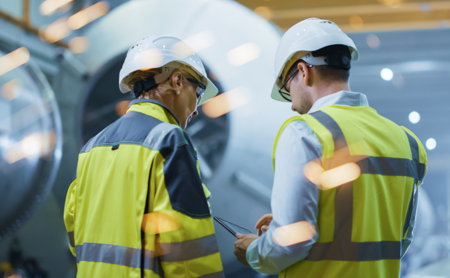 Two men in hard hats working in the manufacturing industry